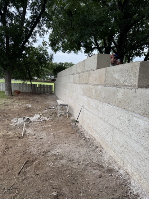 Retaining wall construction in progress with block courses set level